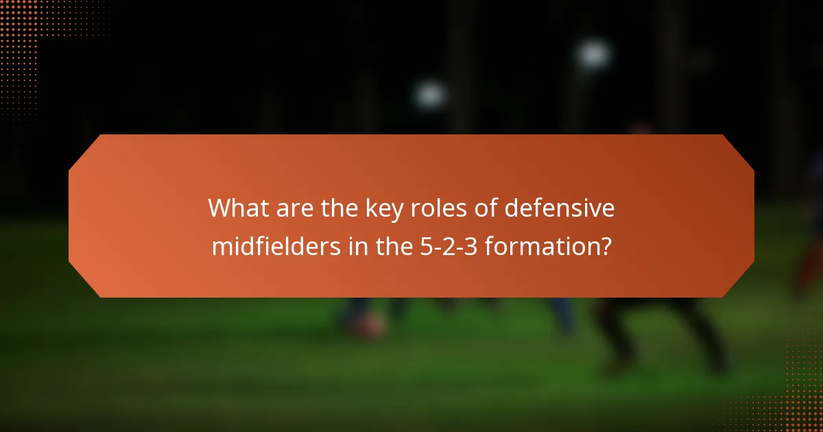 What are the key roles of defensive midfielders in the 5-2-3 formation?